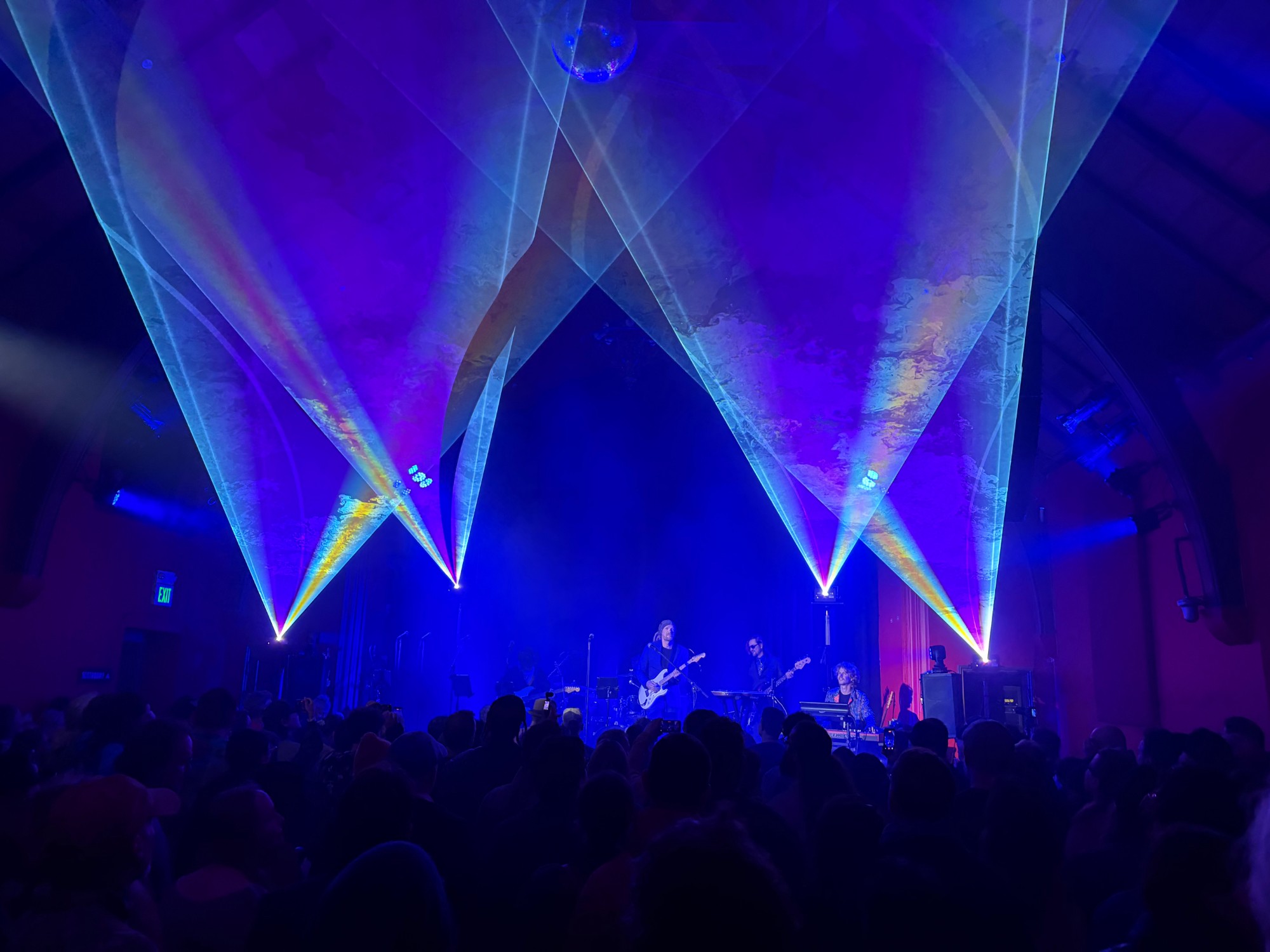 Ben and band on stage under blue laser lights to a packed room